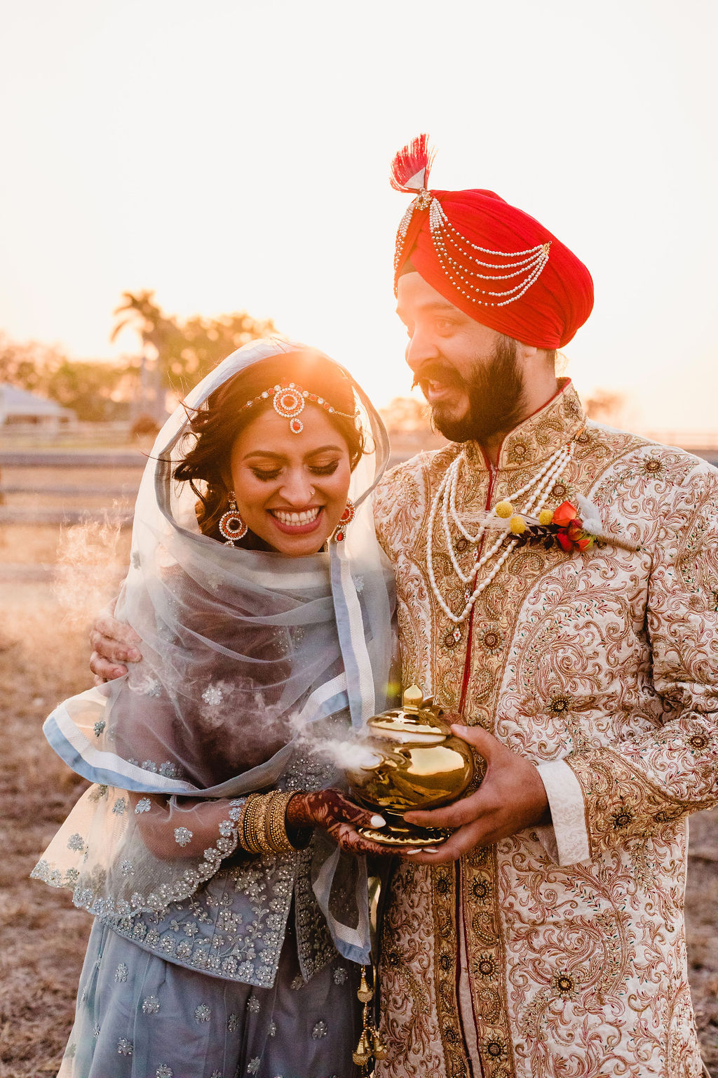 Indian bride and groom holding magic lamp