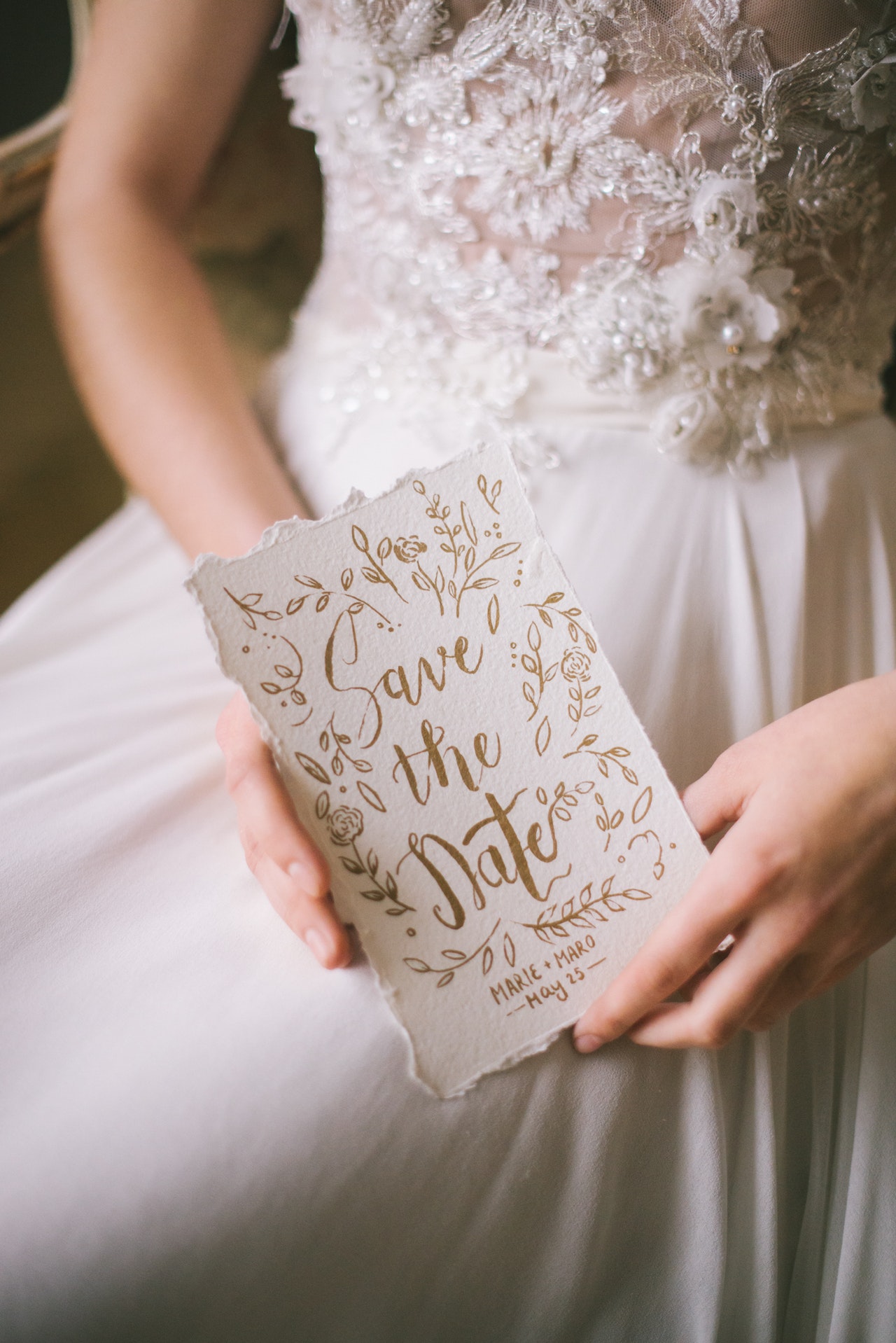 save the date held by bride