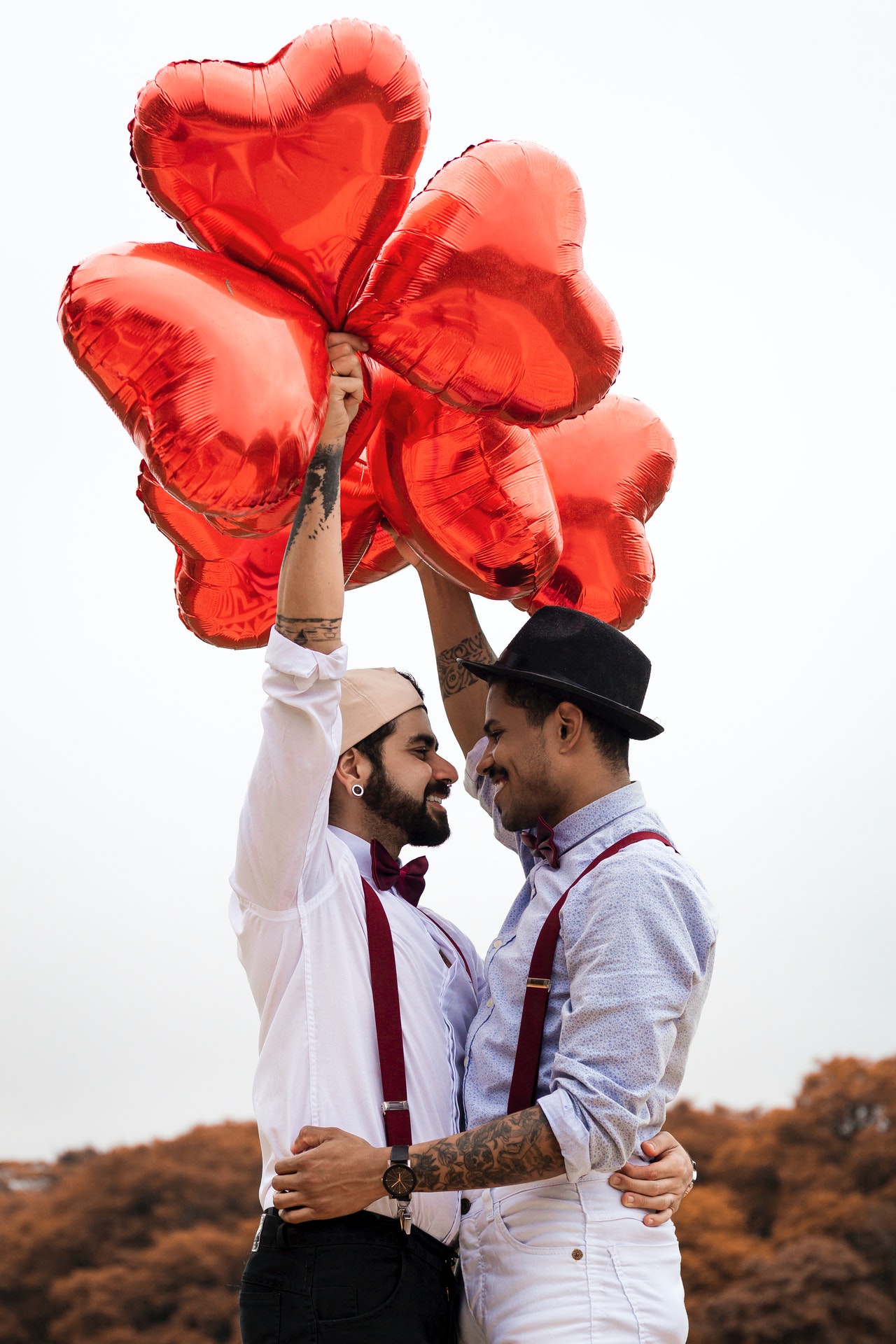 Groom and groom holding balloons